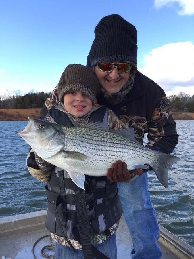 A hybrid striped bass on a cold, bright November day — the trip where the guide noticed that Aaron never once complained about the weather.