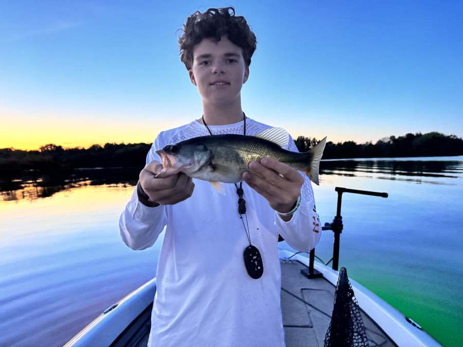 Sunset on the water, fish in hand.